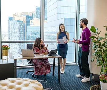 Clients brainstorming in a fully equipped serviced office with a city view at Servcorp’s Commercial Bank Plaza.