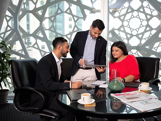 Servcorp team assists clients in a meeting room with skyline views at Doha Tower, West Bay, Doha.